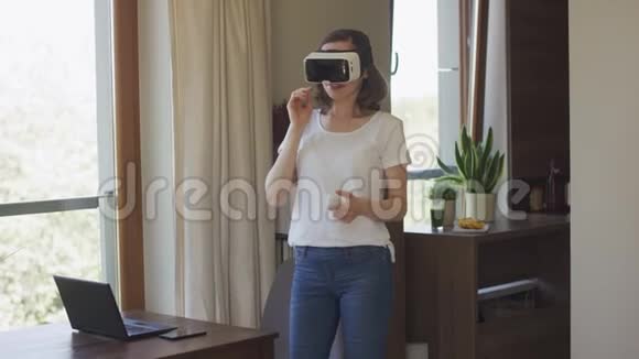 年轻女子手持VR耳机和遥控器视频的预览图