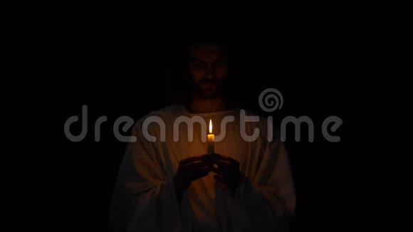 耶稣复活前戴荆棘冠冕的圣人在黑暗中持烛视频的预览图