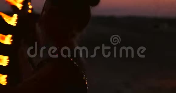 一群男人和女人晚上在沙滩上表演火视频的预览图