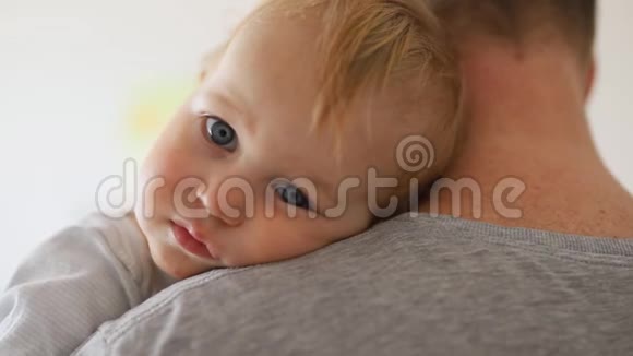 可爱可爱的金发白种人幼儿男孩的特写肖像父亲肩在室内可爱的孩子视频的预览图