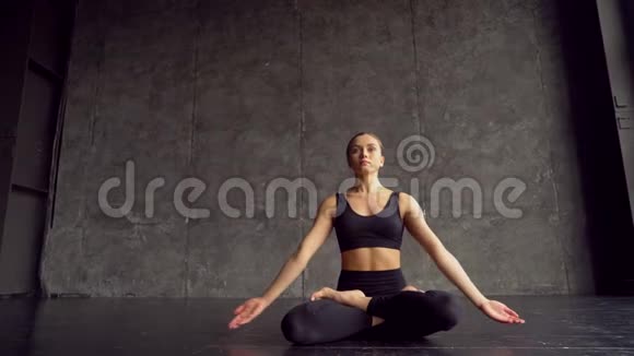 年轻女子坐在莲花姿势练习瑜伽瑜伽女孩坐在床上在瑜伽中冥想和举手视频的预览图