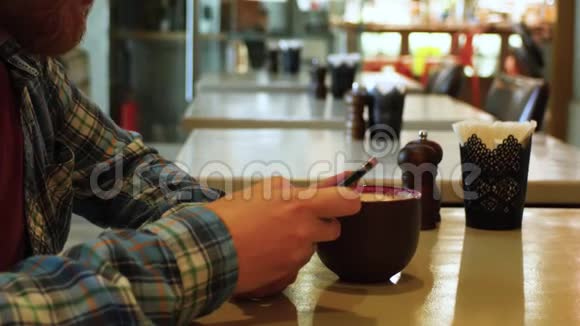 年轻人在咖啡馆里喝茶手里拿着电话学生午餐在咖啡馆商人解决问题视频的预览图
