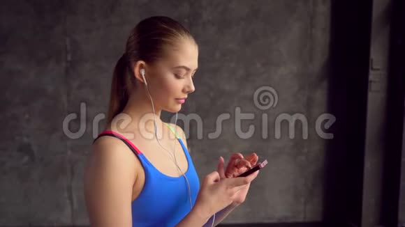 肖像脸年轻女子戴耳机在健身房听音乐运动员微笑锻炼女性健康身体视频的预览图