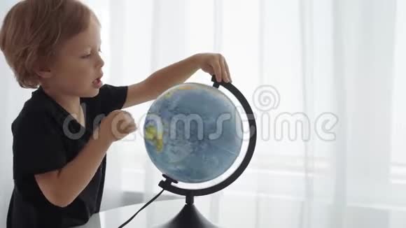 可爱的白种人男孩旋转着地球梦想着旅行视频的预览图