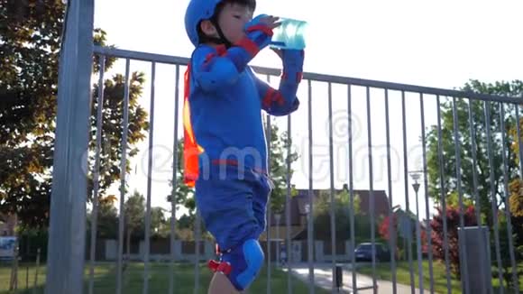 运动儿童从室外的瓶子里喝矿泉水背光视频的预览图