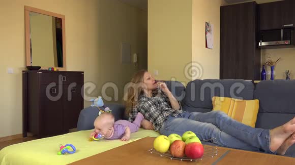 保姆躺在婴儿附近的沙发上愤怒的父亲穿西装4K视频的预览图