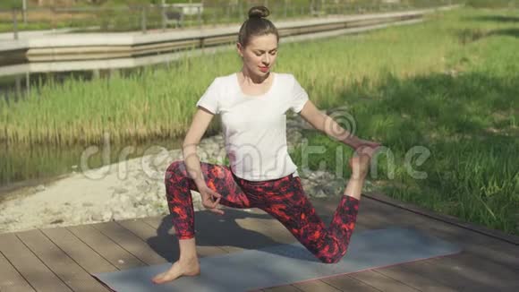 在大自然中做瑜伽的光荣女人视频的预览图