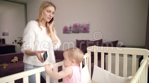 婴儿在手机上看卡通现代母亲生活幼儿欣赏电影视频的预览图