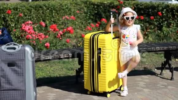 带黄色大手提箱的儿童游客小女孩等着旅行视频的预览图