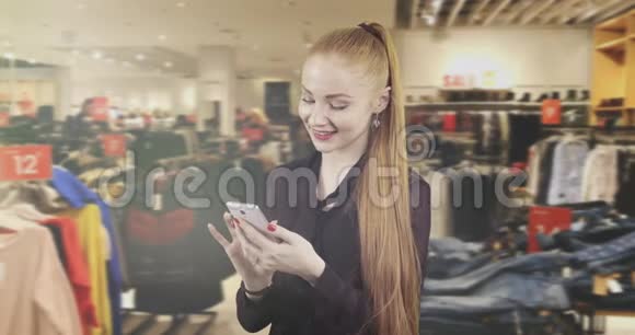 一位留着红色长发的迷人女人在一家时尚服装店的手机上留言视频的预览图