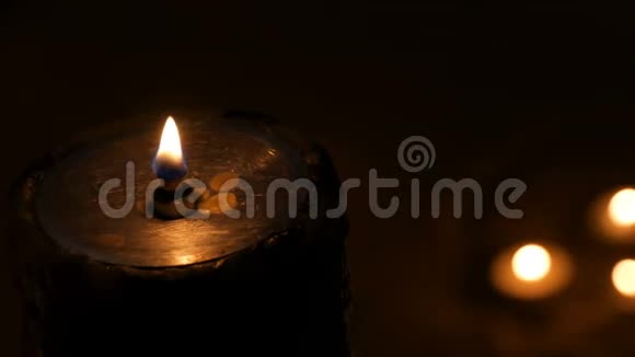在黑暗中和背景上一支大型铁制防火蜡烛发出的火焰燃烧得很小视频的预览图