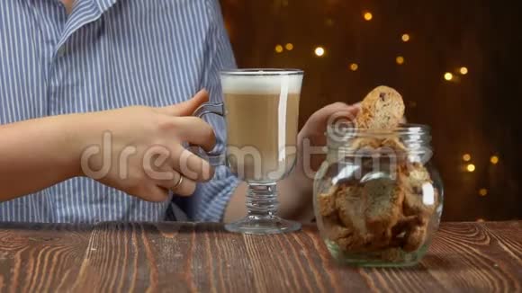 手把脆饼从罐子里拿出来放进咖啡里视频的预览图