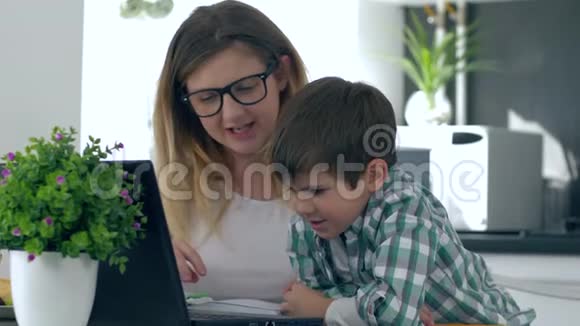 家庭教育带妈妈的小男孩用笔记本电脑学习视频的预览图