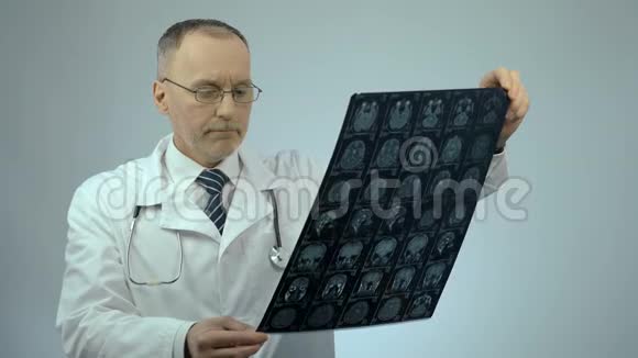 不高兴的医生看核磁共振脑扫描对病人的健康状况感到不安视频的预览图