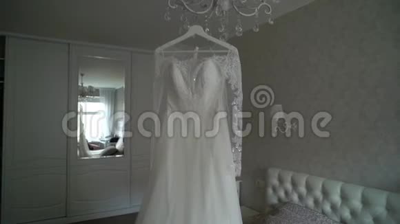 豪华婚纱挂在卧室里令人惊叹的新娘蕾丝礼服的剪影早上的准备开始视频的预览图