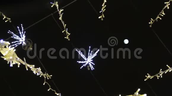 为圣诞节和新年庆祝而装饰的街道装饰灯光花环的底部景观视频的预览图