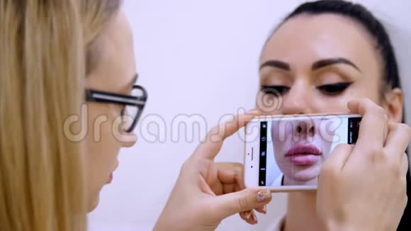 医务处一位戴眼镜的女医生在给病人打针后在电话上病人的嘴唇视频的预览图