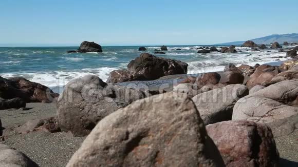 带海浪的沙滩低镜头角岩石视频的预览图