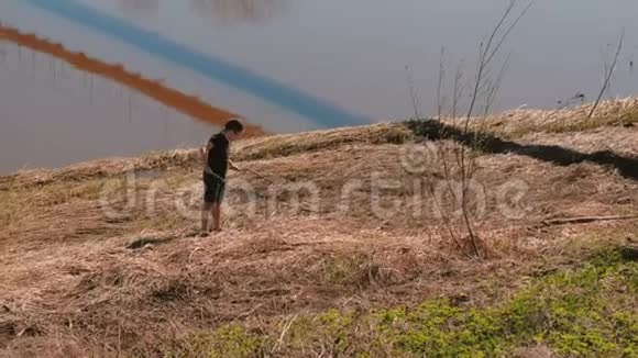 人在河岸的干草里捉蛇视频的预览图