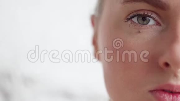 年轻白种人漂亮的脸白色背景上有一双灰色的大眼睛视频的预览图