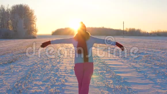 太阳落山时的滑稽女子举起双臂旋转太阳慢动作4K视频的预览图