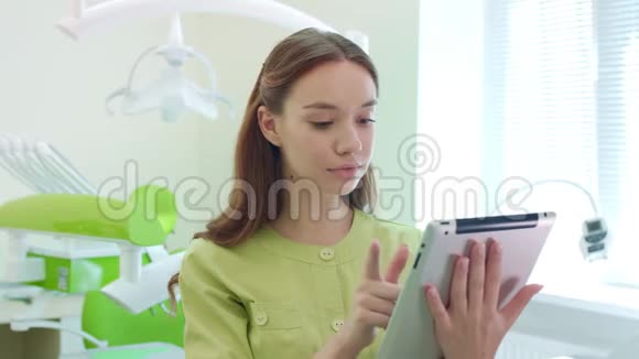 在牙科办公室做平板电脑的医学生女医生用药片视频的预览图