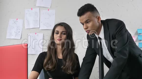 年轻女孩在办公室里和一个穿西装的员工调情轻轻地抚摸他的脸颊他对面调情骚扰视频的预览图