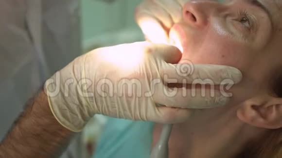 使用特殊牙科设备治疗美丽女性患者的门诊牙医视频的预览图
