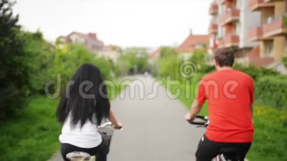 有吸引力的漂亮夫妇的肖像穿着休闲服装牛仔裤整体骑复古自行车一起享受自行车视频的预览图
