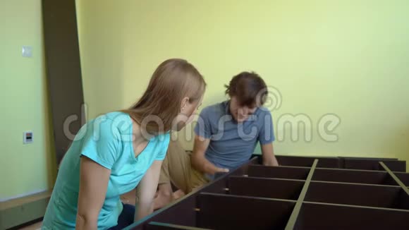 年轻的一家人用架子组装橱柜视频的预览图