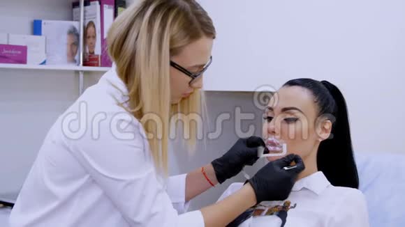 在诊所的美容室里医生在病人的嘴唇上麻醉在注射透明质酸之前视频的预览图