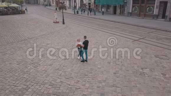 年轻夫妇一起在街道的中心有一束花的人从空中射击视频的预览图
