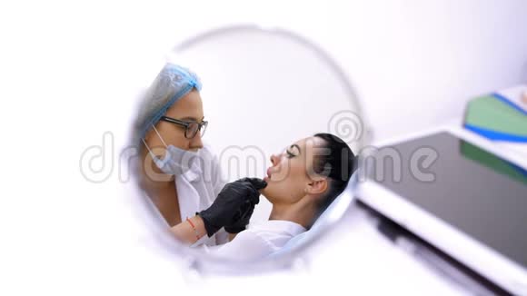 临床美容室一名白色女性医生在病人的嘴唇注射透明质酸程序视频的预览图