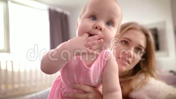 累妈妈抱着孩子幼儿学习站立美丽的孩子和母亲视频的预览图