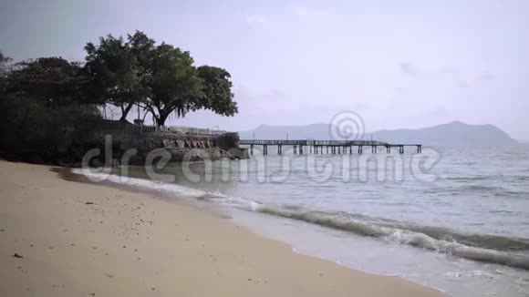 美丽的海滩有一个石头阳台和一棵大树泰国芭堤雅4K视频的预览图