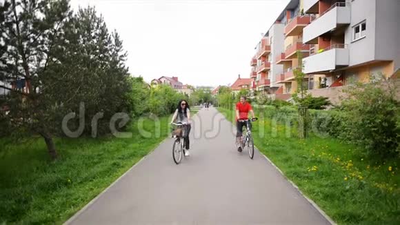 一对漂亮的情侣穿着休闲装牛仔裤整体骑着复古自行车一起骑自行车视频的预览图