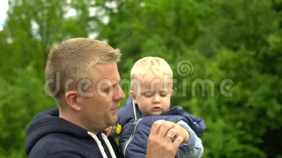 年轻快乐的父亲手牵着小儿子在公园视频的预览图