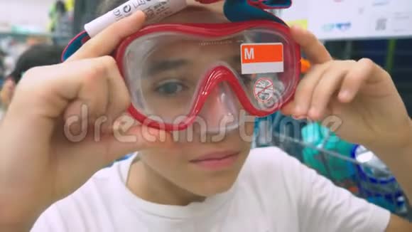 一个快乐的青少年的肖像谁测量面具潜水在商店视频的预览图