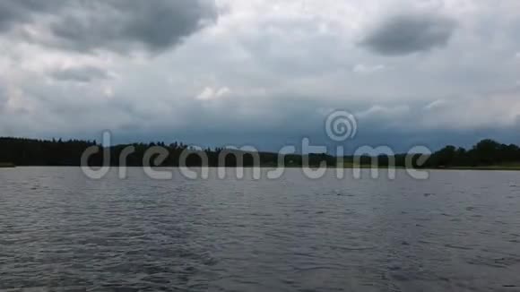 美丽的日落森林湖景湖岸绿树葱茏天空布满了沉重的雷云视频的预览图