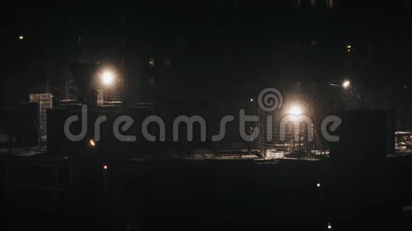 建筑工地住宅区建筑施工人员在冬季夜间下雪视频的预览图