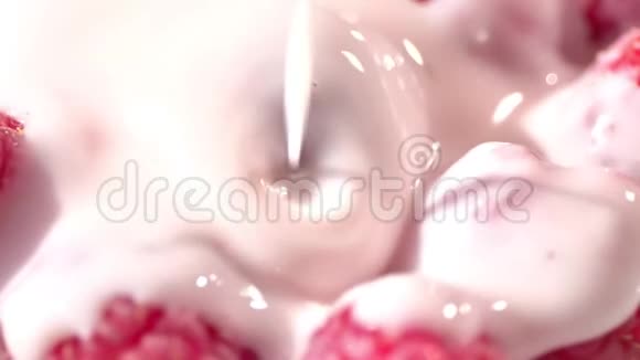 高角度的粘稠新鲜酸奶或牛奶或奶油倒入红色成熟浆果特写视频的预览图