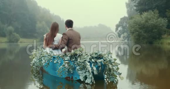 爱的欧库普正在享受雾蒙蒙的湖的自然同时漂浮在装饰着绿色草药的浪漫的船上龙龙视频的预览图