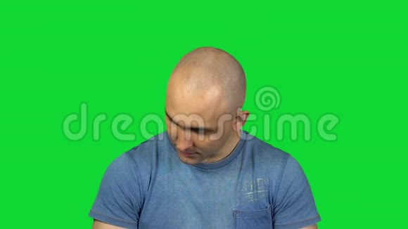 在绿色背景上炫耀秃头视频的预览图
