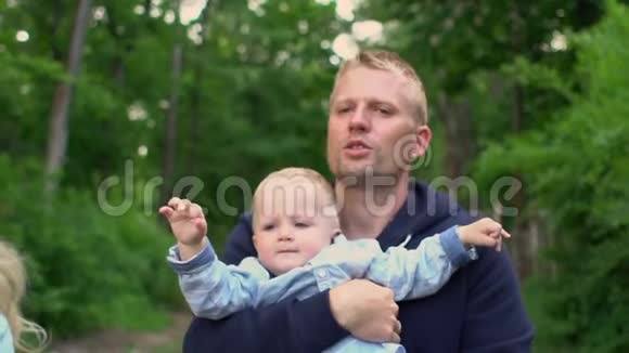 幸福的家庭小男孩父亲手里的小男孩在公园散步视频的预览图