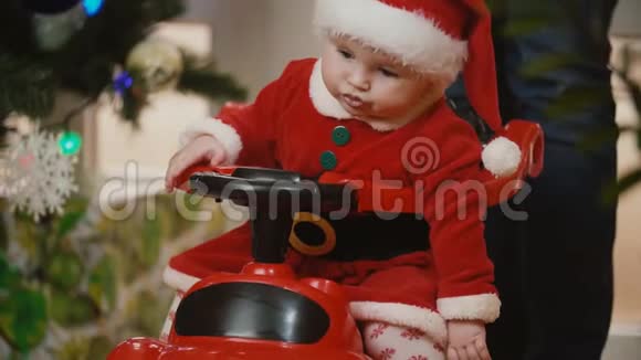 一个穿着圣诞服的小女孩在玩具车里翻滚视频的预览图