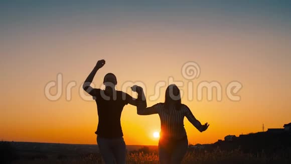 欢乐的情侣在日落时跳跃视频的预览图