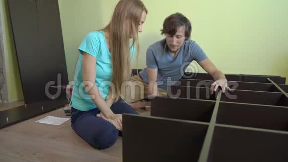 年轻的一家人用架子组装橱柜视频的预览图