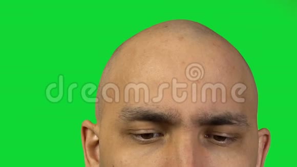 半张脸接触绿色背景的秃头男人视频的预览图