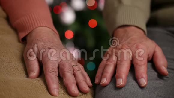 老人的双手在圣诞树前等候视频的预览图