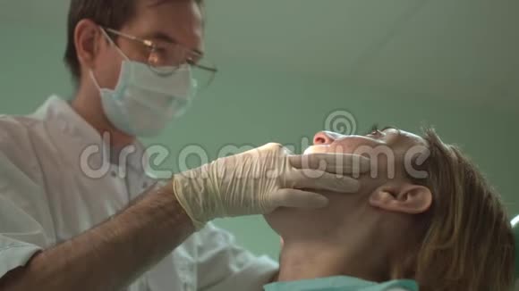 年轻成功的牙科医生用牙科设备为临床上的女性病人治疗牙齿视频的预览图